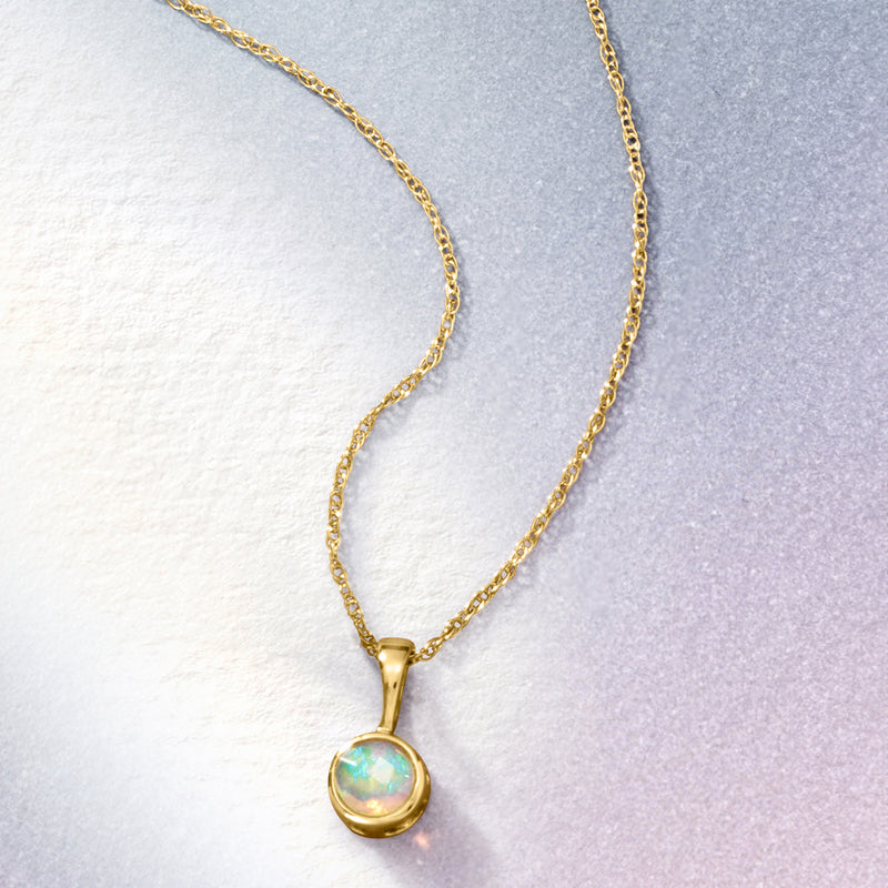 Yellow gold opal pendant necklace featuring round opal pendant on link chain