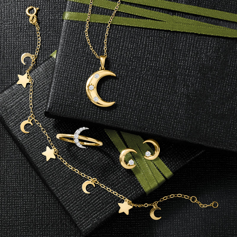 14kt yellow gold moon and stars bracelet laid on a dark jewelry case