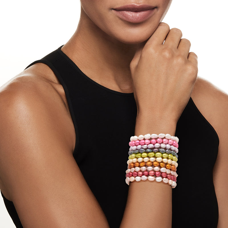 Stacked cultured pearl stretch bracelets with pink, white, and gold beads on wrist