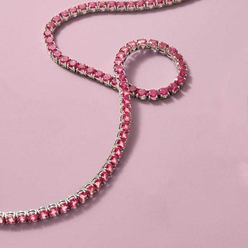 Sterling silver tennis necklace with pink topaz round stones, angled close-up
