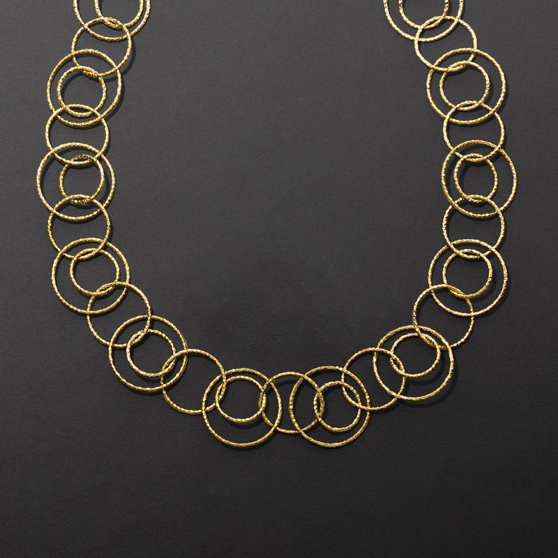 Gold over sterling multi-circle necklace close-up of textured and polished ring circles.