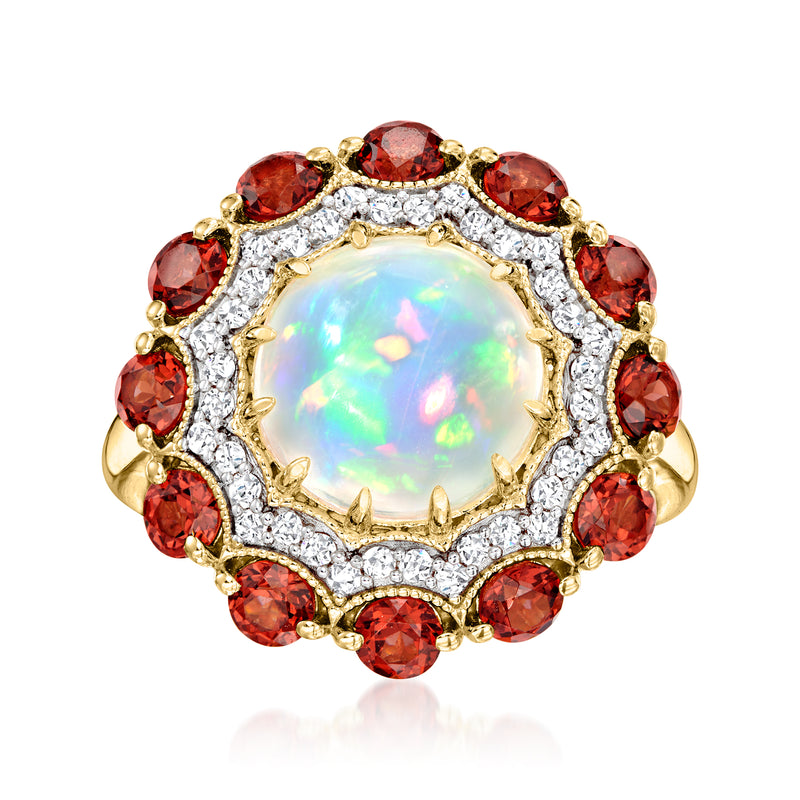 Opal center gemstone ring with red oval stones, halo of clear crystals, gold-tone setting