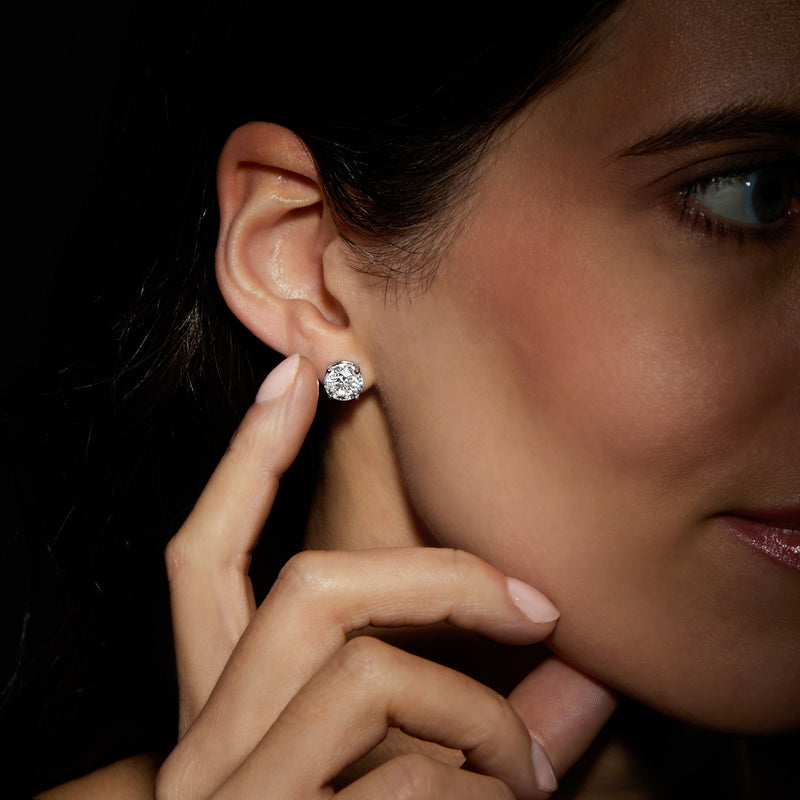 Round diamond stud earring in 14kt white gold on model's ear