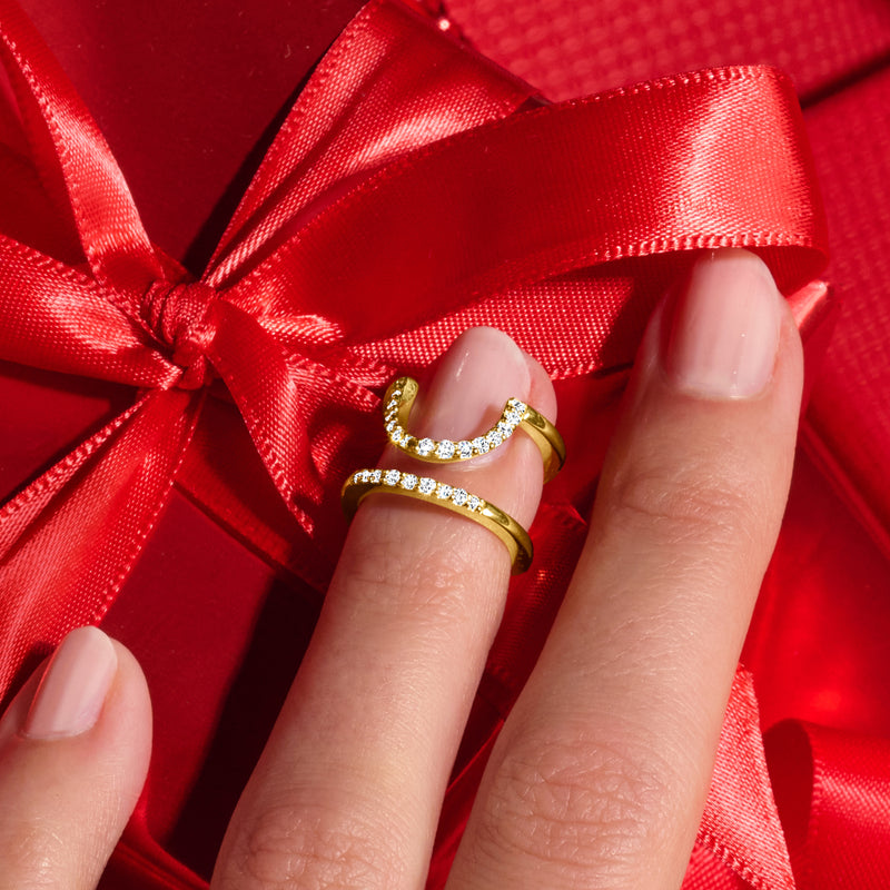 Gold diamond nail ring on finger, curved V shape with round sparkle stones