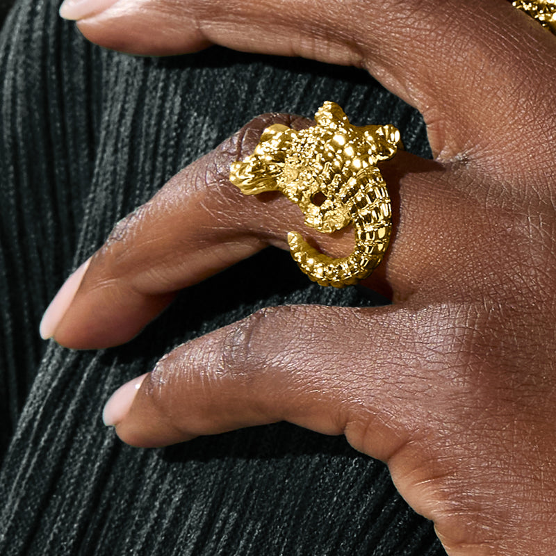 18kt yellow gold alligator ring on finger, textured scale pattern visible