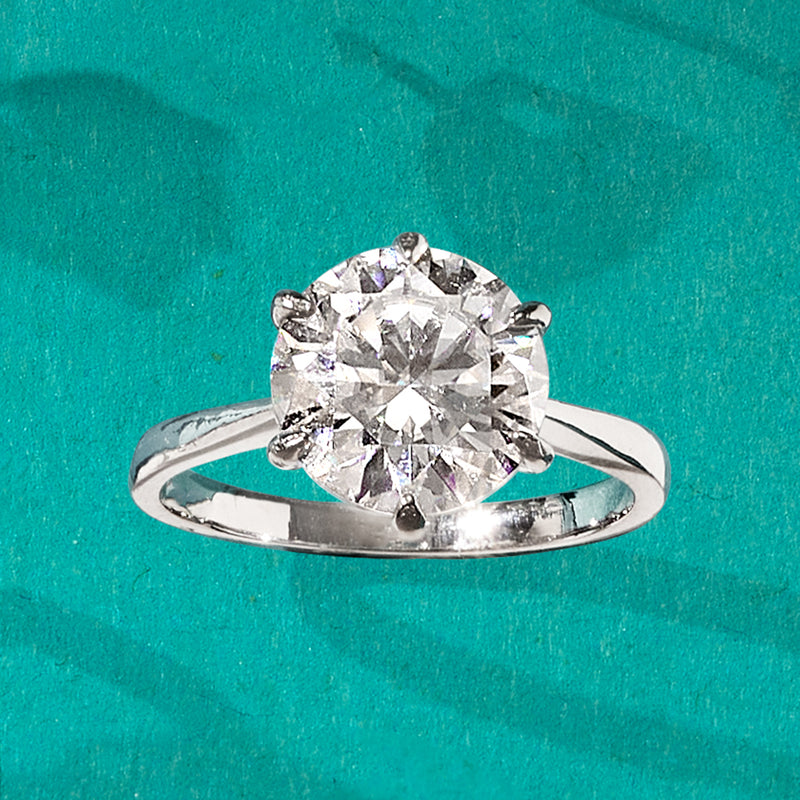 Sterling silver solitaire ring with round moissanite center and curved polished band