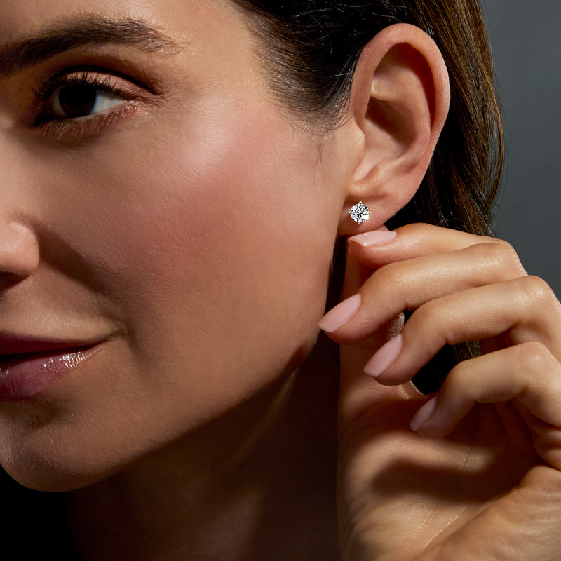Platinum lab-grown diamond stud earrings on ear with one stone visible