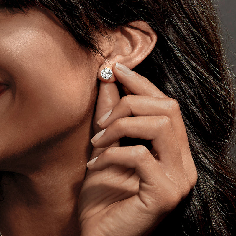 Platinum diamond stud earrings worn on ear, round brilliant lab-grown stones