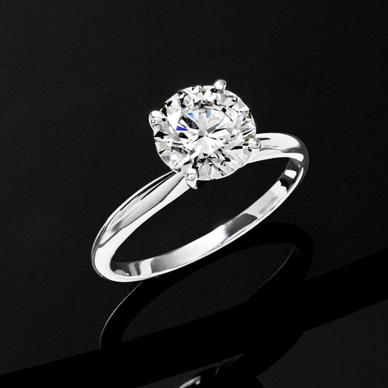 Round diamond solitaire ring in 14kt white gold, angled view of center prongs