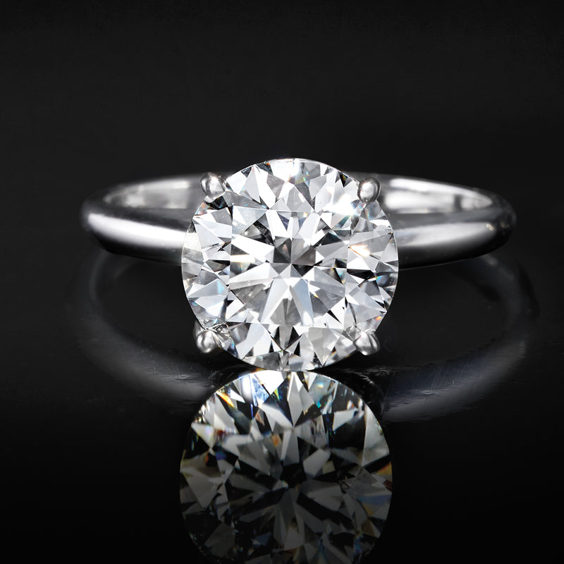 14kt white gold solitaire ring with round diamond, reflective close-up