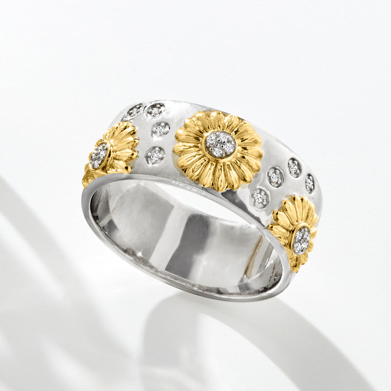 Gold-and-silver sunflower ring with round diamond center stones on a wide polished band
