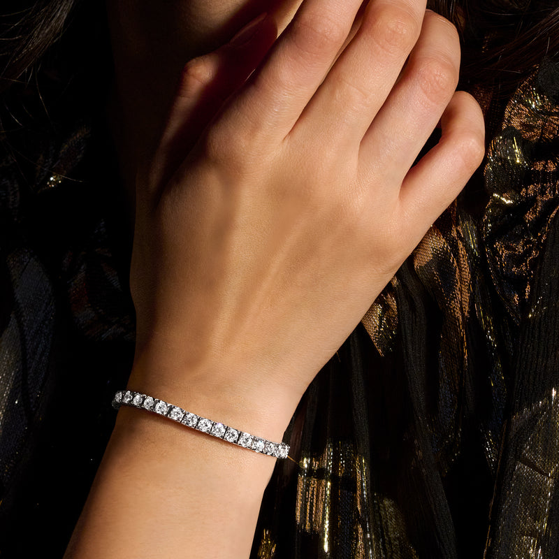 Diamond tennis bracelet worn on wrist with white-gold band and round-cut stones