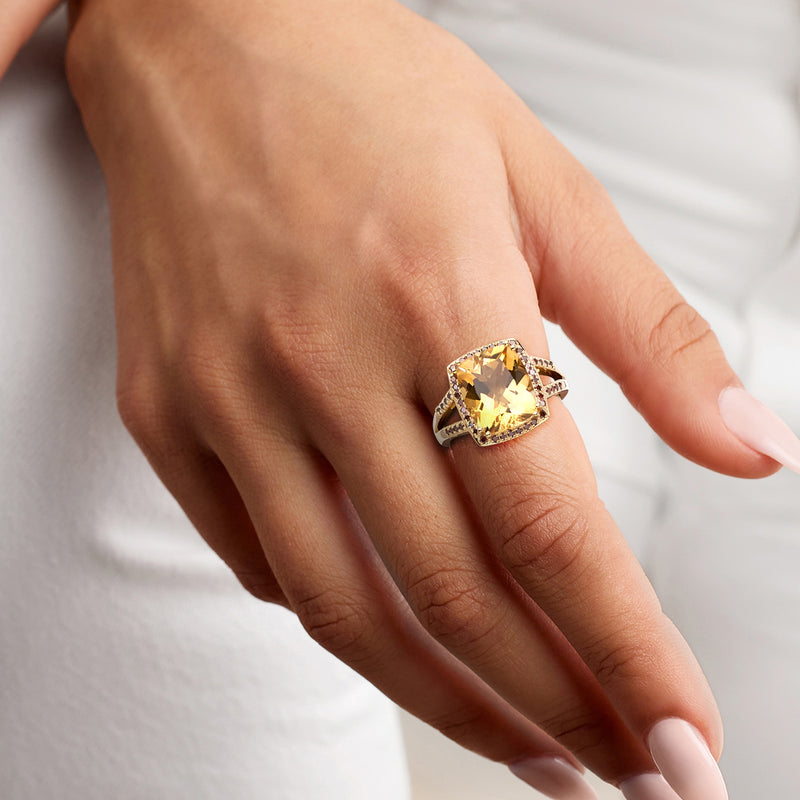 Gold ring with oval yellow citrine and red halo, worn on hand