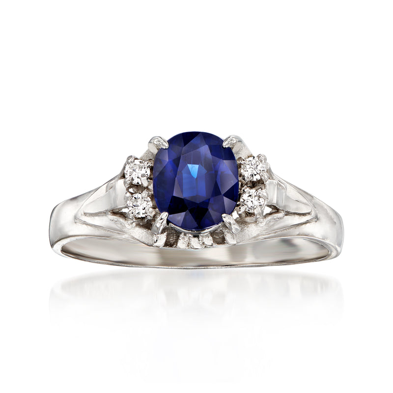 Platinum ring with oval deep-blue sapphire center and small diamond side clusters