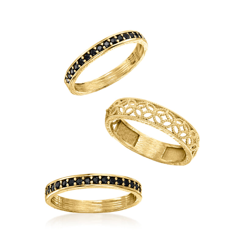 Three gold rings set: black stone band, lattice scrollwork, and smooth band