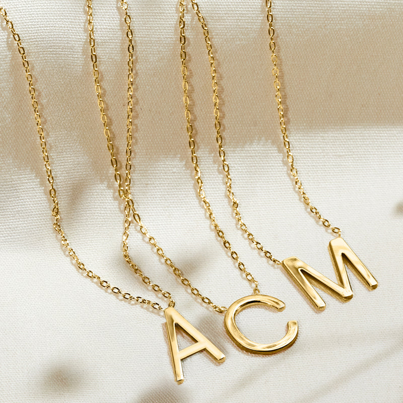 14kt yellow gold initial pendants on fine chain, including A, C, and M