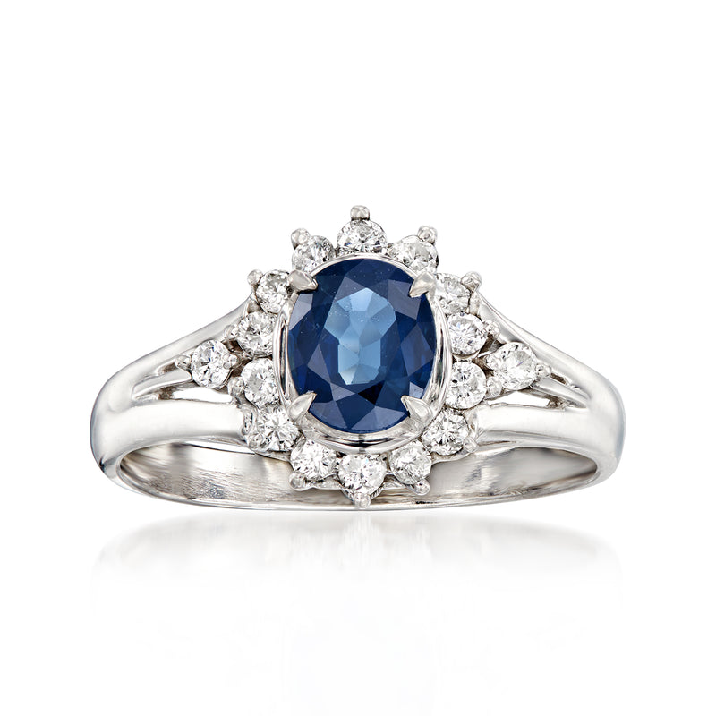 Platinum vintage ring with oval dark blue sapphire and round diamond halo