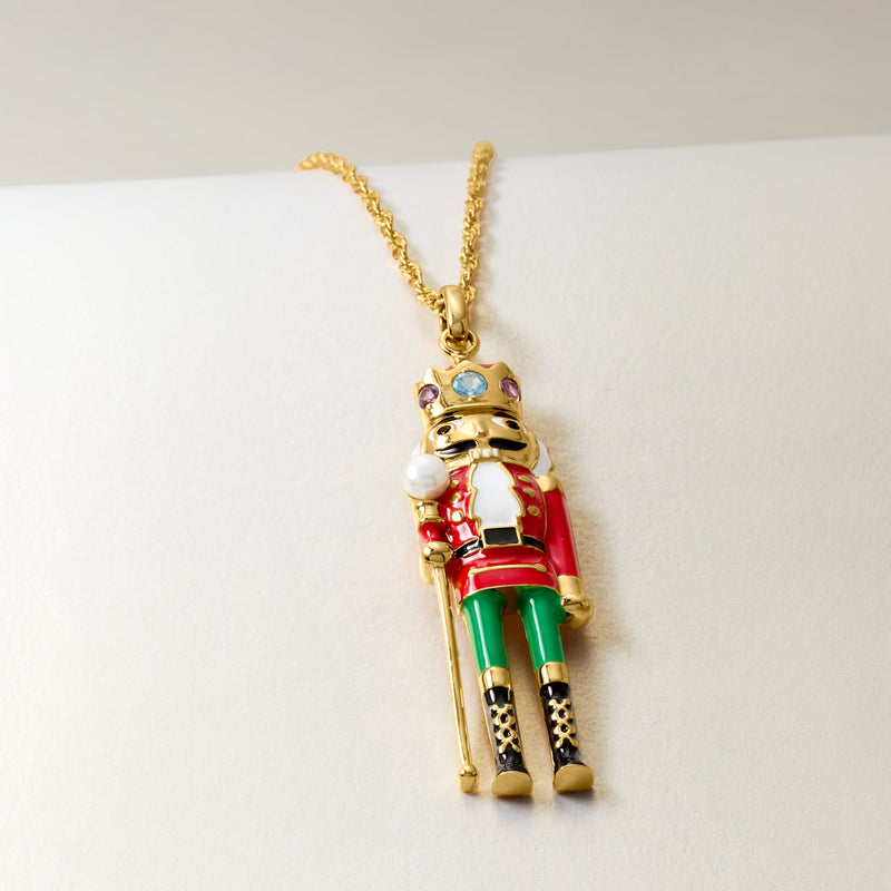 Nutcracker pendant on gold chain with red, green and purple enamel, pearl detail