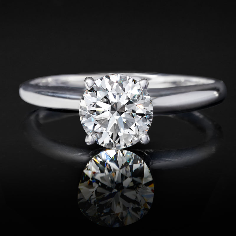 White gold solitaire ring with round center diamond and polished band