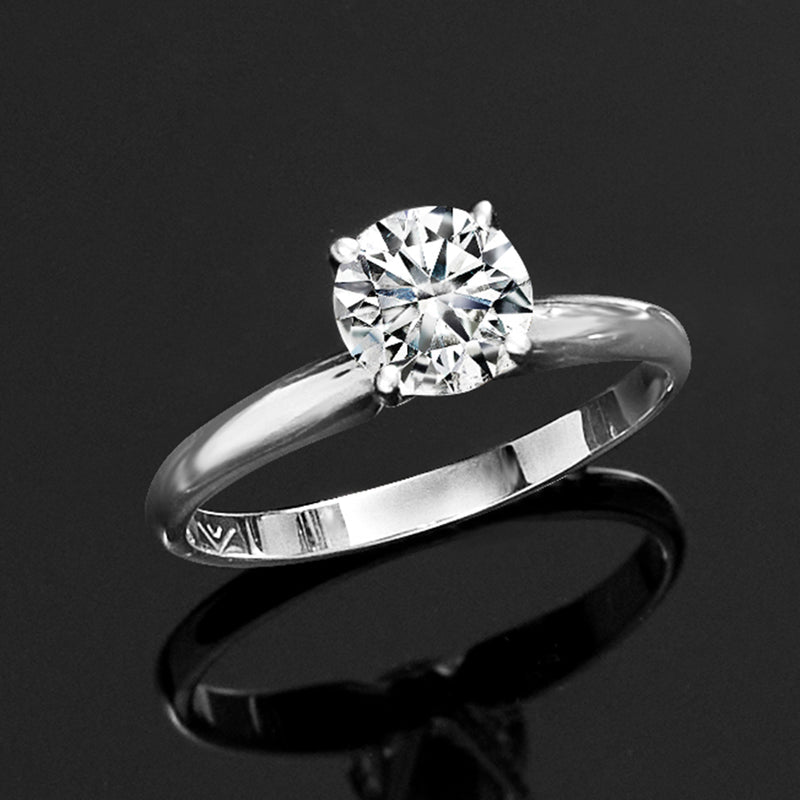 White gold solitaire ring with round diamond, side view of curved band