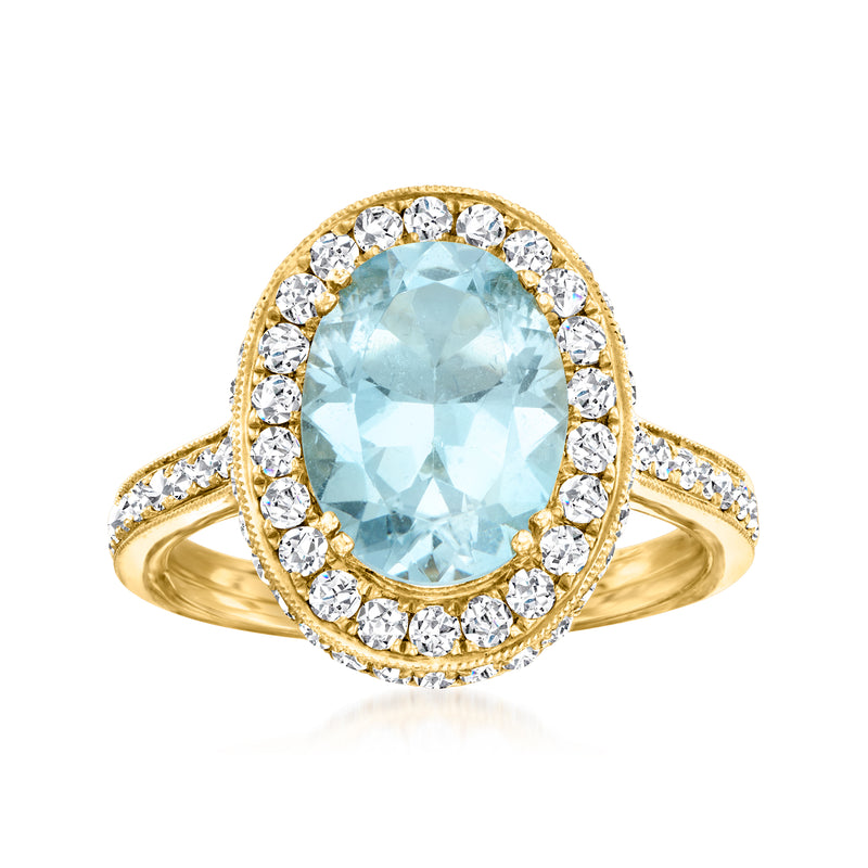 Oval aquamarine gemstone ring in 18k yellow gold with diamond halo and side stones