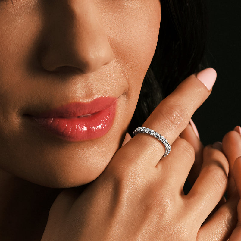 Lab-grown diamond eternity band on finger with small round stones in 14kt white gold