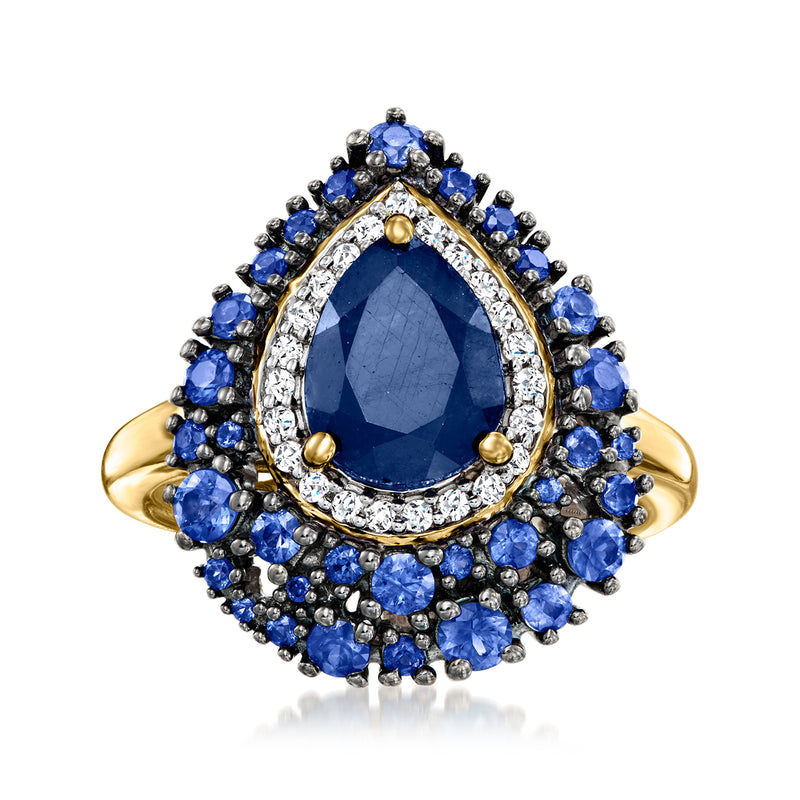 Oval sapphire centerpiece ring in 18kt gold with blue stone halo and white accents