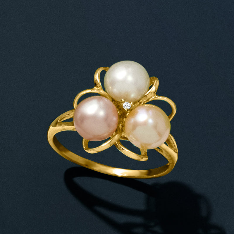 Gold ring with three cultured pearls and a tiny diamond in a flower setting