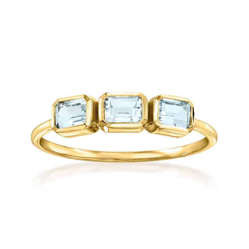 Three-stone aquamarine ring in 14kt yellow gold, emerald-cut side stones