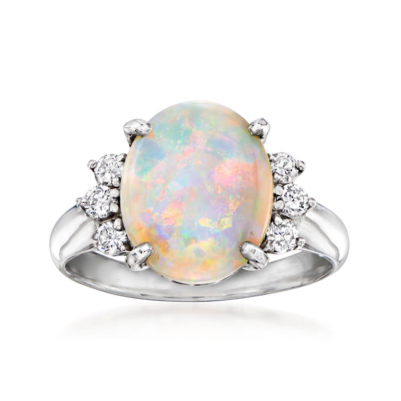 Vintage platinum ring with oval opal center and diamond side stones, prong set