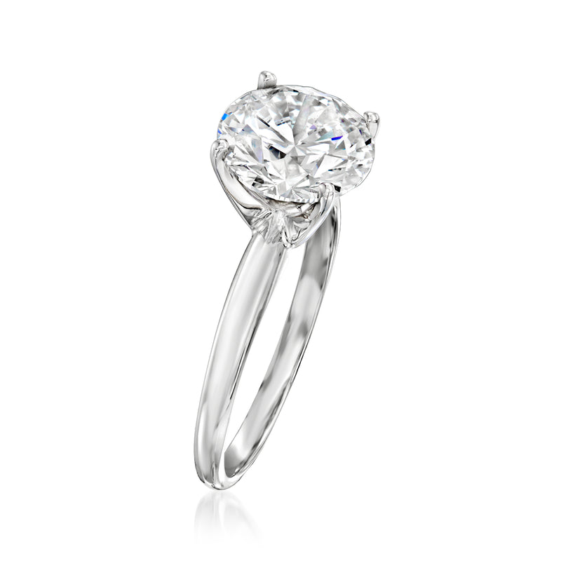 Platinum solitaire ring with round brilliant diamond, curved band and four prongs.