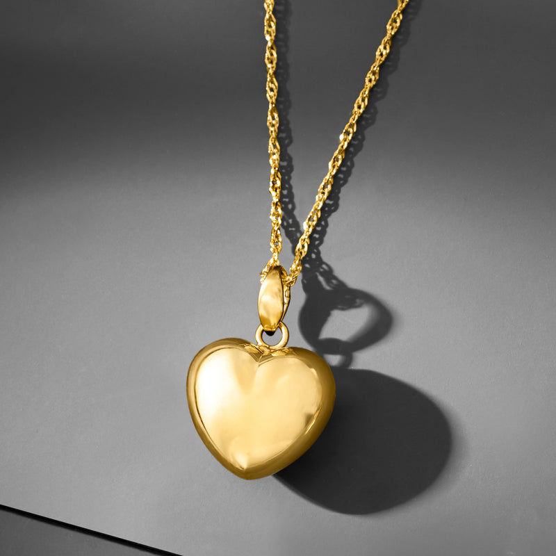 Gold-tone puffed heart pendant necklace, angled view with bold heart shine