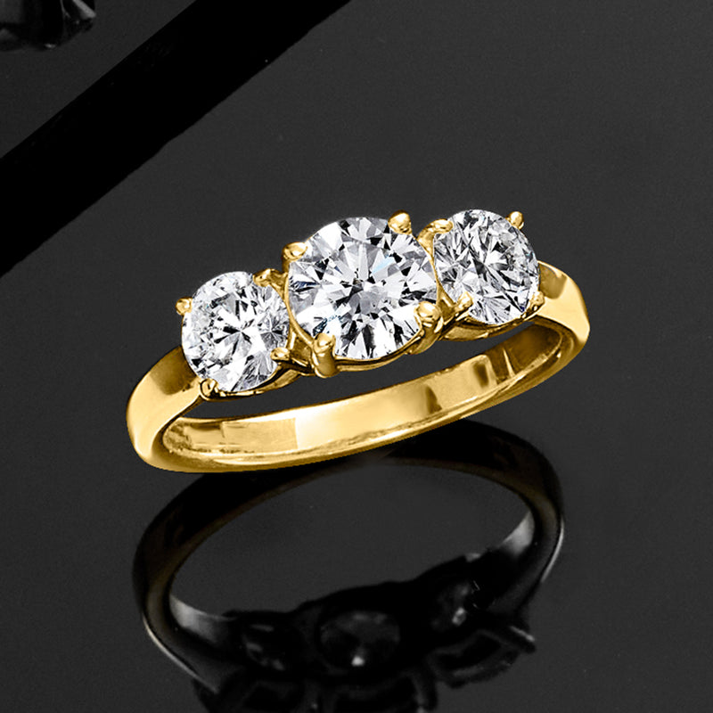 Three-stone diamond ring in 14kt yellow gold, diagonal view showing three round diamonds