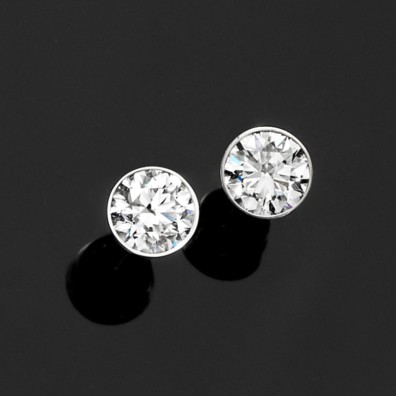 Round lab-grown diamond stud earrings, bezel-set in 14kt white gold, two studs.