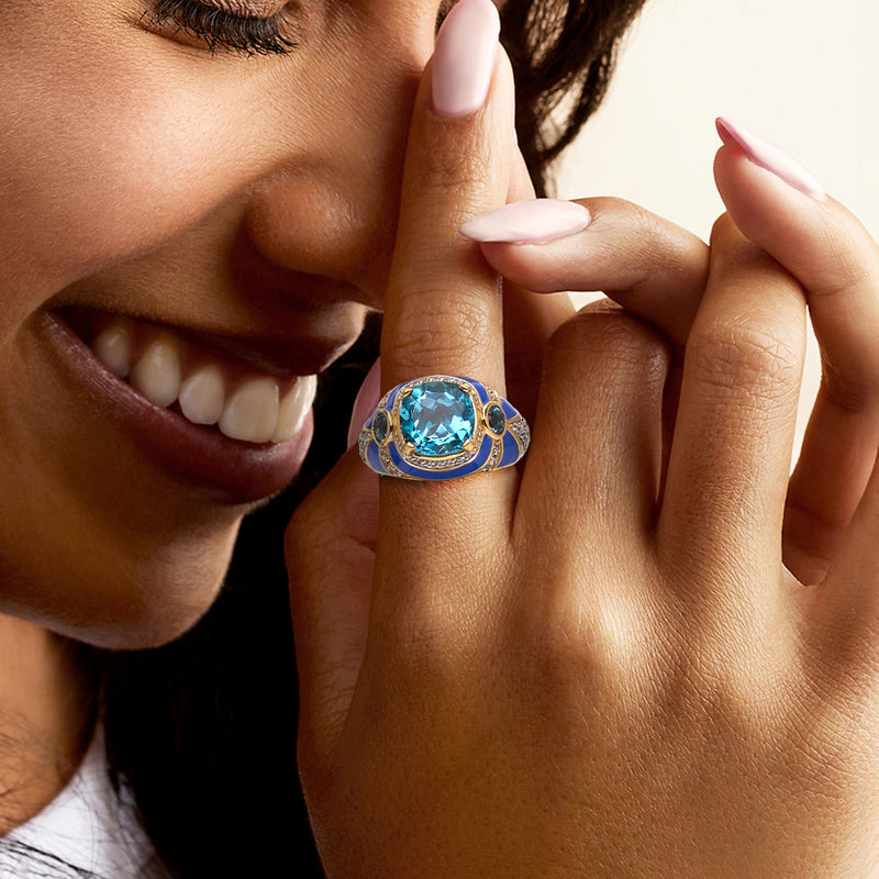 Blue gemstone ring on finger with blue enamel bezel and gold-tone setting