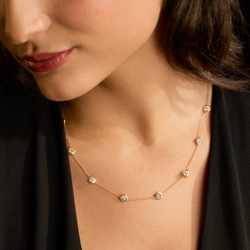 Close-up of 14kt yellow gold station necklace with round diamond-like stations