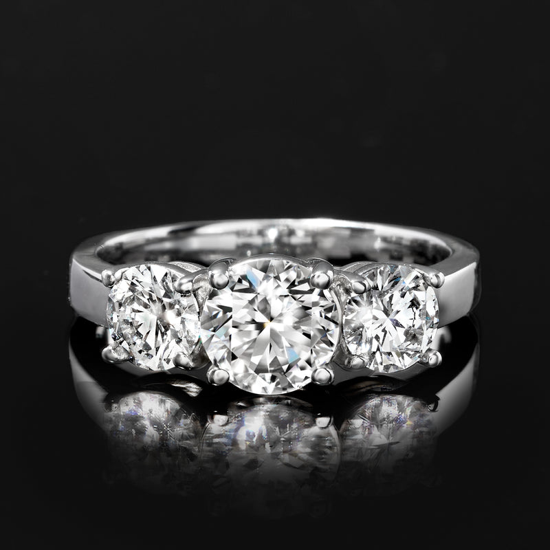 Three-stone diamond ring, close-up of three round diamonds in white gold prong settings
