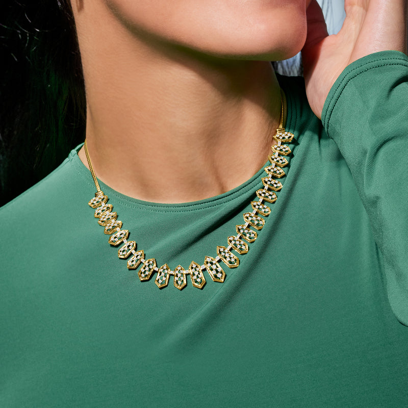 Gold-tone diamond-look geometric necklace on model neckline with oval linked stones