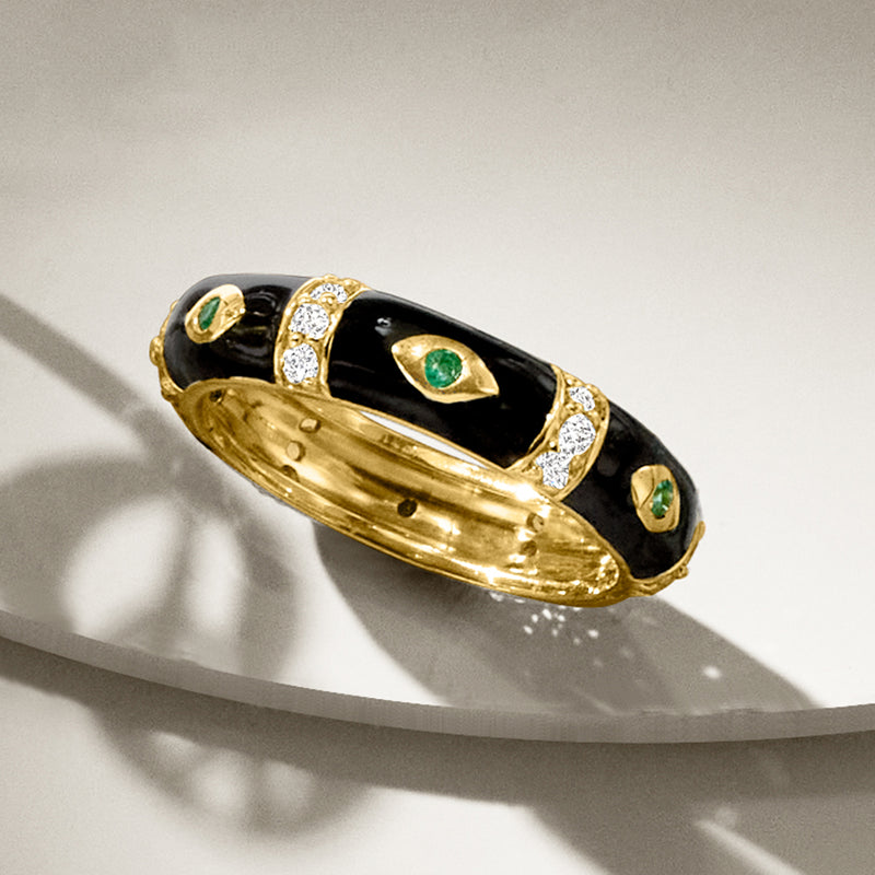Gold evil eye ring with black enamel, green eye stone, and white sparkle accents