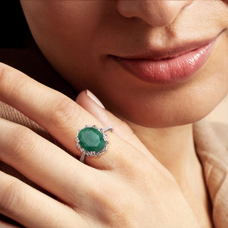 Sterling silver oval green gemstone ring on hand with white stone halo
