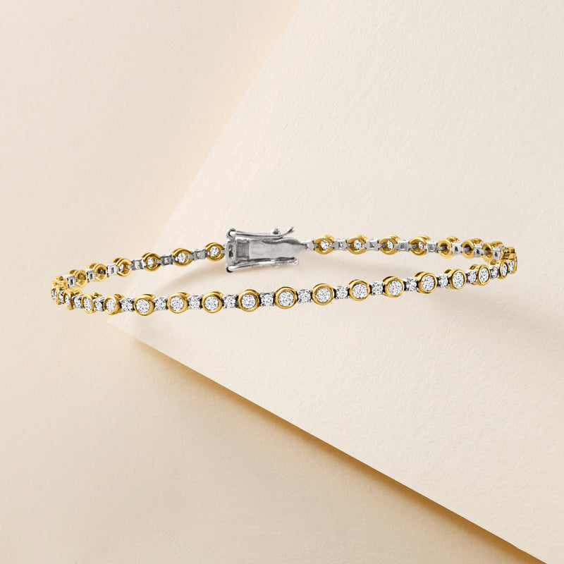 Two-tone gold diamond tennis bracelet with round bezel-set stones and box clasp