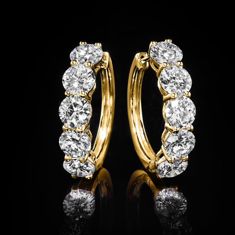 Gold hoop earrings with five round diamonds in a vertical five-stone setting