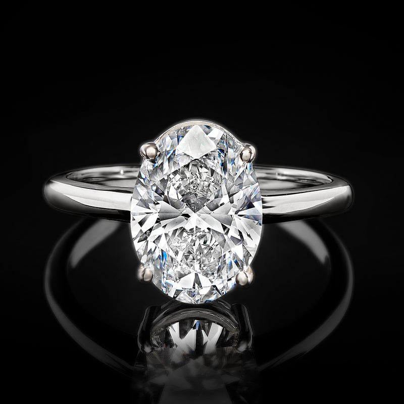 Oval diamond solitaire ring close-up with four prongs and 14kt white gold band