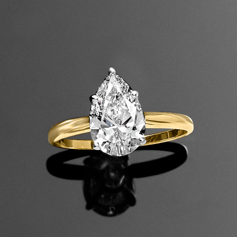 Pear-shaped diamond solitaire ring with 14kt yellow gold band and prong-set diamond