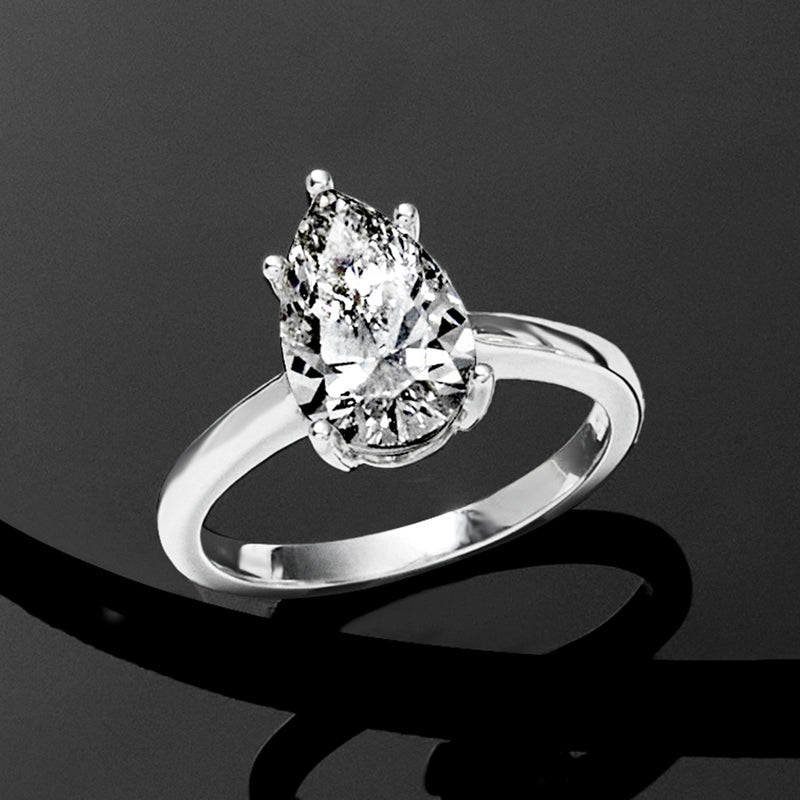 Pear-shaped diamond solitaire ring in white gold, angled view of crown and band