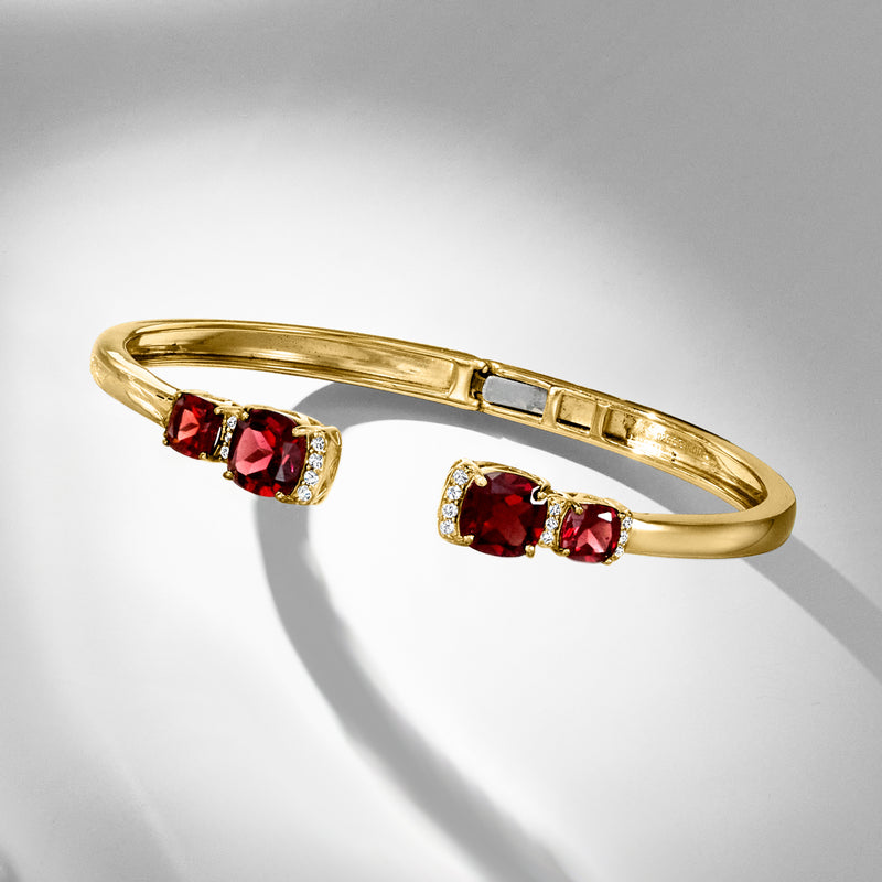 Gold cuff bracelet with red garnet and white topaz stones, open buckle clasp