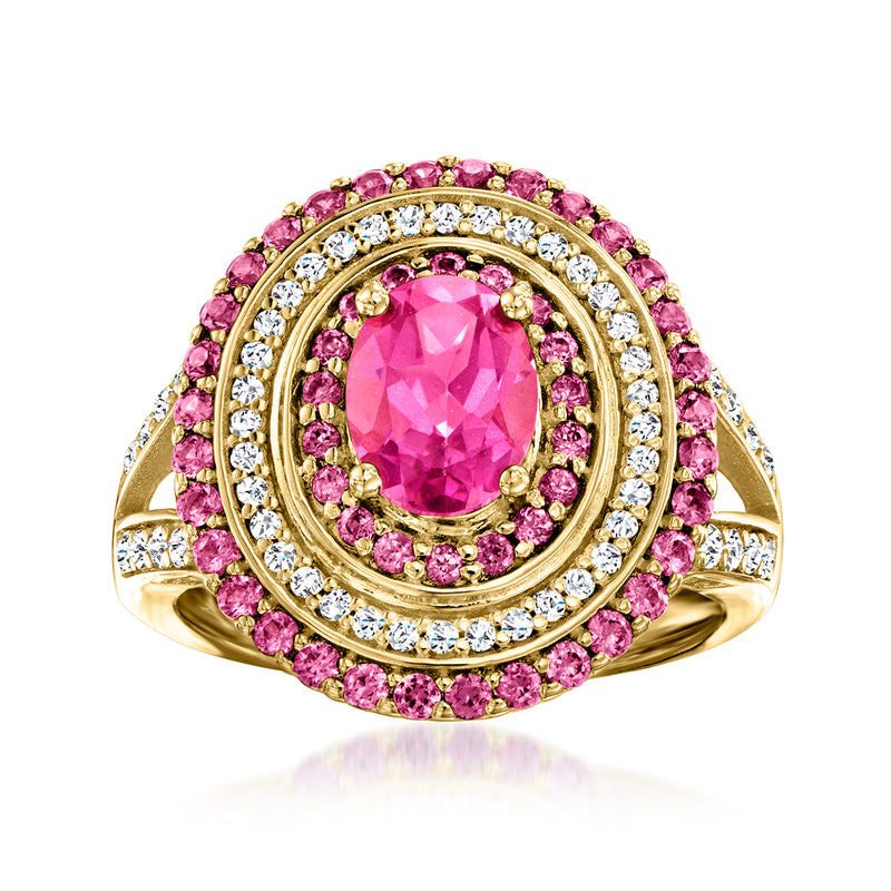 Gold-tone ring with oval pink gemstone center, pink halo, and white stone border