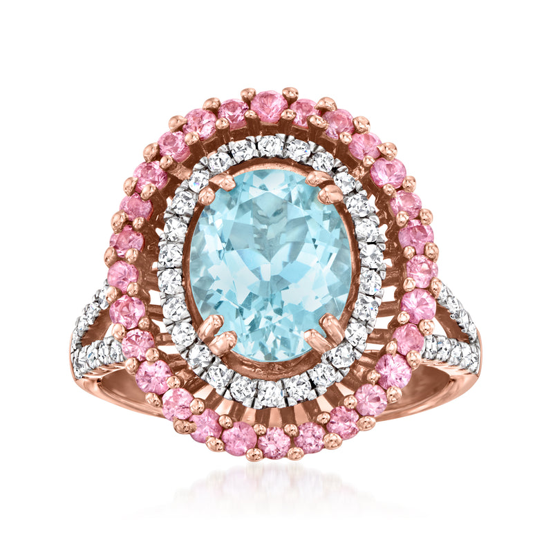 Oval aquamarine center ring with pink sapphire halo, diamond border, rose gold band.