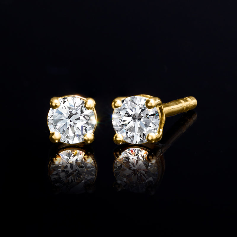 Round diamond stud earrings with gold bezel setting and small prongs.