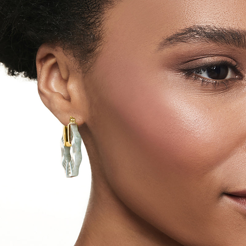Jade hoop earrings in gold-tone with carved mint-green panels, close-up on ear